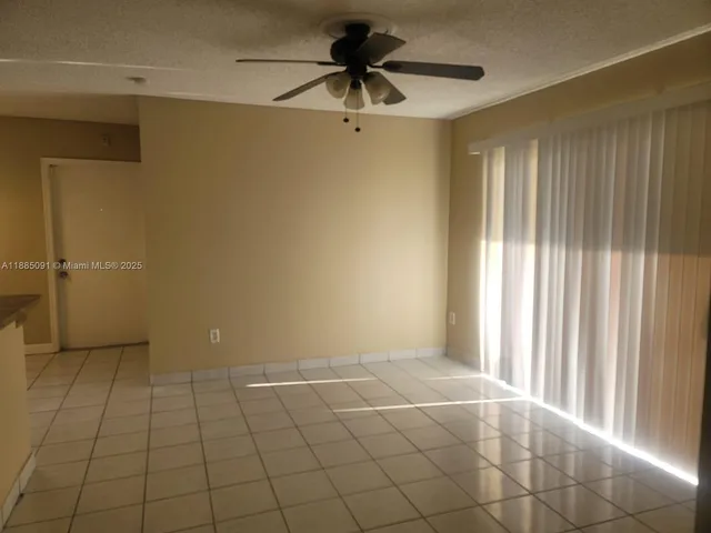 a view of a livingroom with a chandelier fan and windows