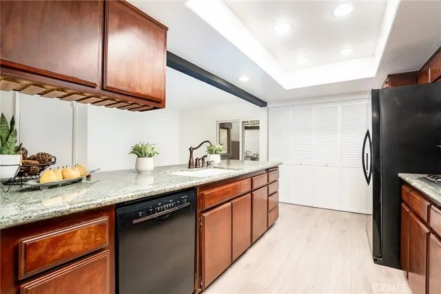 a kitchen with stainless steel appliances granite countertop a sink a stove and a refrigerator