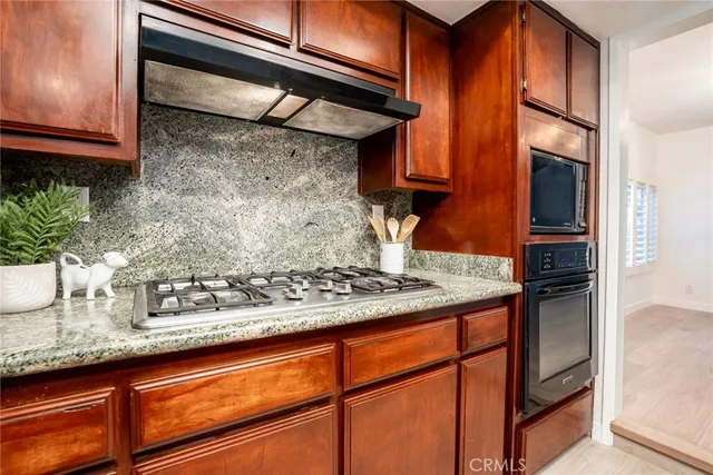 a kitchen with stainless steel appliances granite countertop wooden cabinets and a counter top