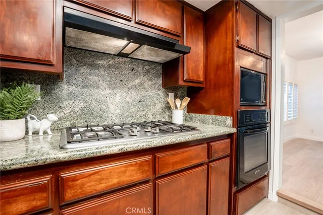 a kitchen with stainless steel appliances granite countertop a sink and a refrigerator