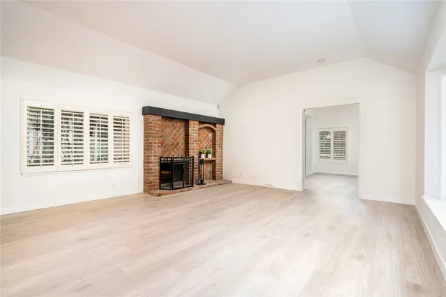 a view of an empty room with a window and fire place