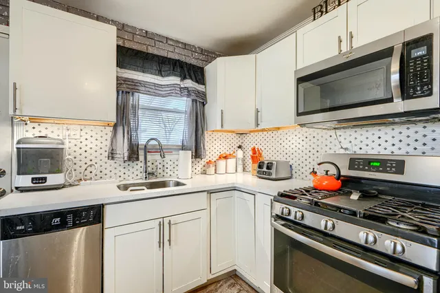 a kitchen with stainless steel appliances granite countertop a stove microwave and sink