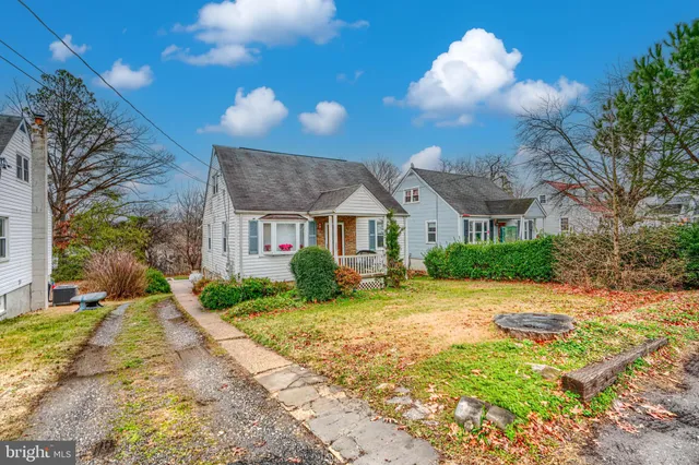 a view of a brick house next to a yard with big trees