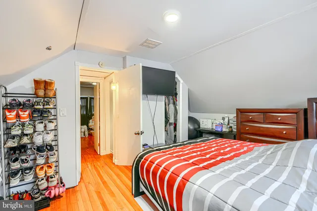 a bedroom with a bed and a large mirror on the dresser