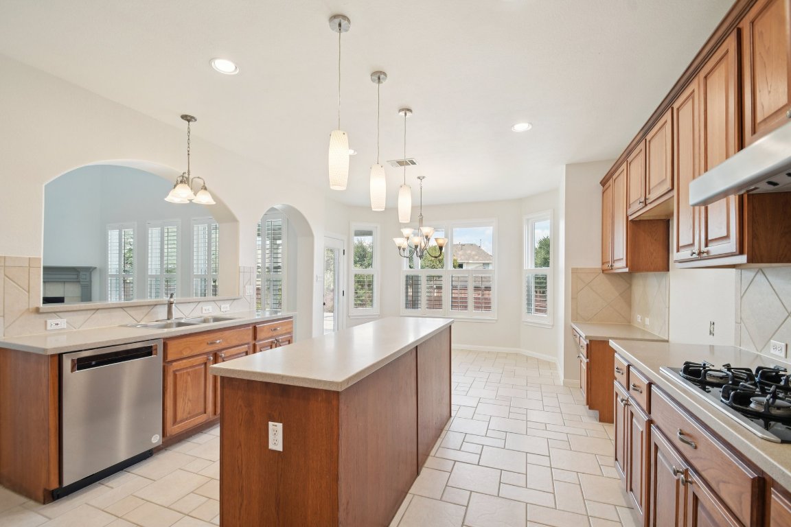 12421 Gun Metal Drive Austin, TX 78739 - Photo 14 of 40 a large kitchen with kitchen island a sink stainless steel appliances and cabinets