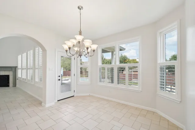 a view of an empty room with wooden floor and a ceiling fan