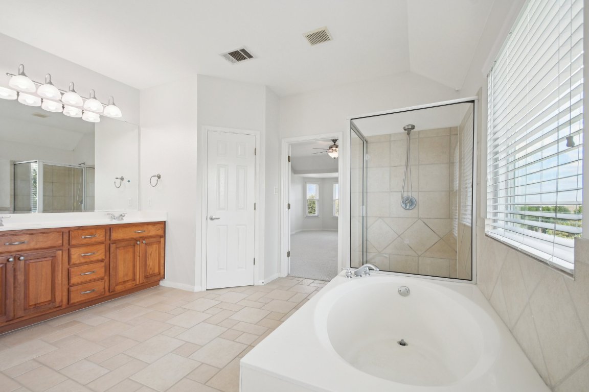 12421 Gun Metal Drive Austin, TX 78739 - Photo 25 of 40 a spacious bathroom with a tub shower sink and mirror