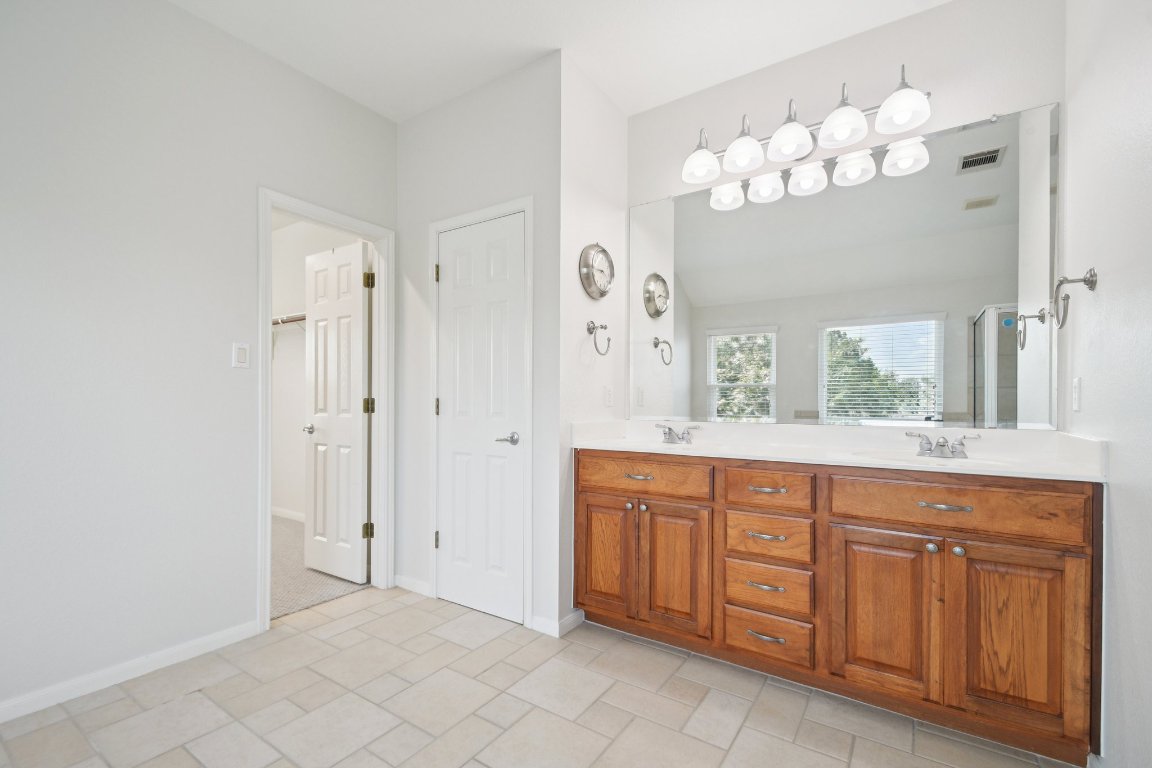 12421 Gun Metal Drive Austin, TX 78739 - Photo 27 of 40 a spacious bathroom with a granite countertop double vanity sink mirror and