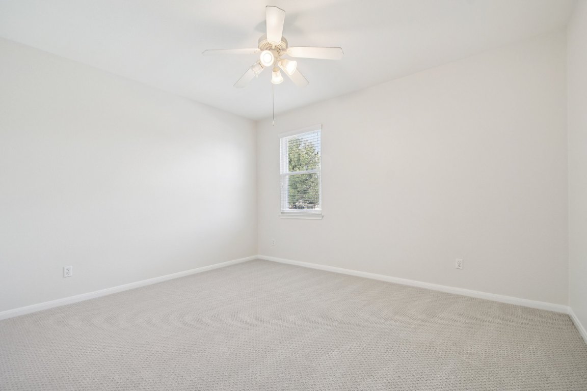 12421 Gun Metal Drive Austin, TX 78739 - Photo 35 of 40 an empty room with a chandelier fan and windows