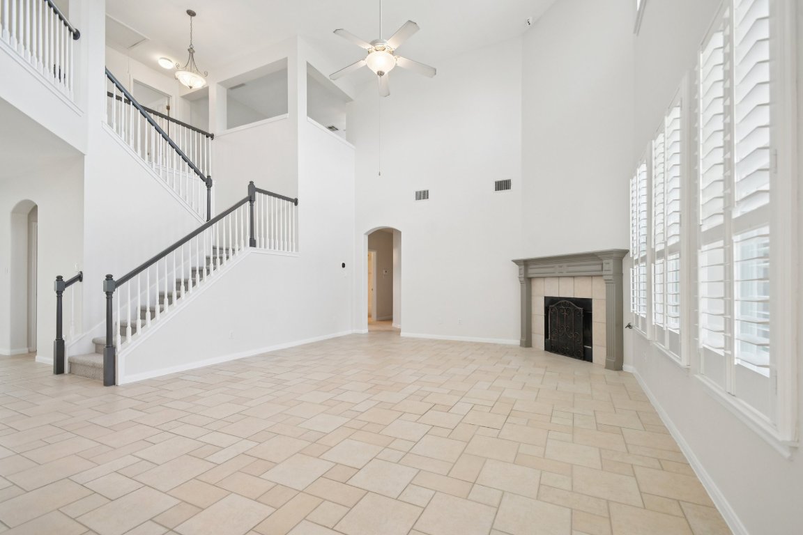 12421 Gun Metal Drive Austin, TX 78739 - Photo 9 of 40 a view of an empty room with a fireplace and a window