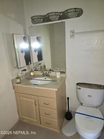 a bathroom with a toilet a sink and mirror