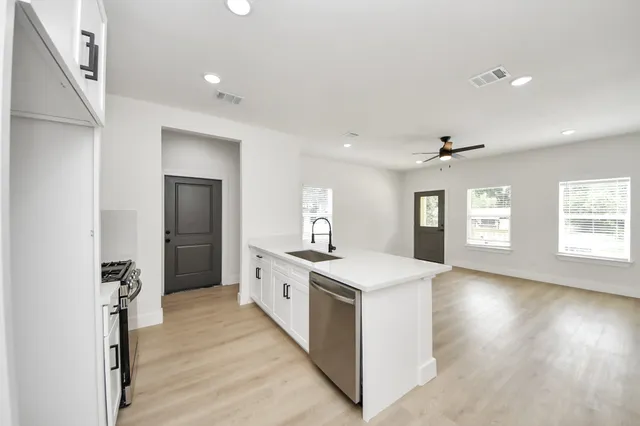 a kitchen with a stove a refrigerator and a stove top oven