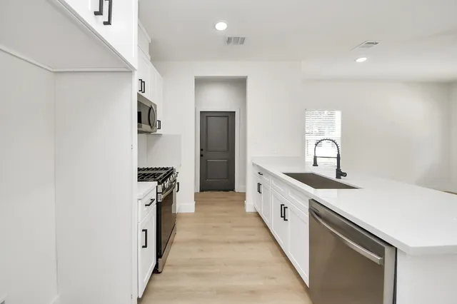 a kitchen with a sink and white cabinets