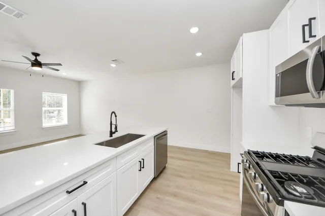 a kitchen with a sink stove and microwave