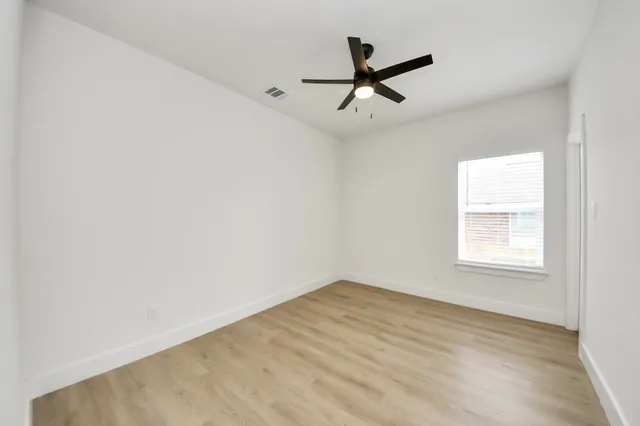 a view of a big room with wooden floor closet and windows