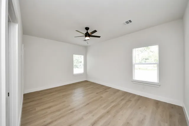 wooden floor in an empty room with a window