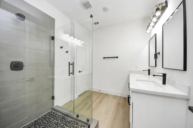 a bathroom with a shower sink and mirror