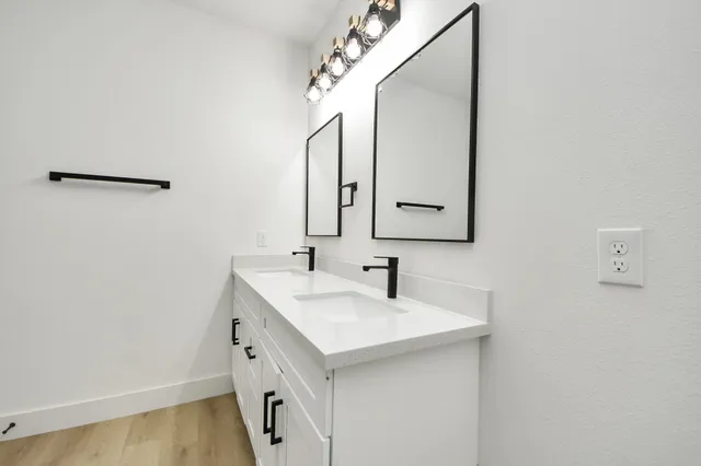 a bathroom with a double vanity sink and a mirror