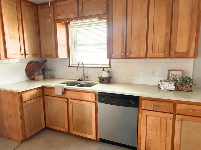 a kitchen with a sink cabinets and window