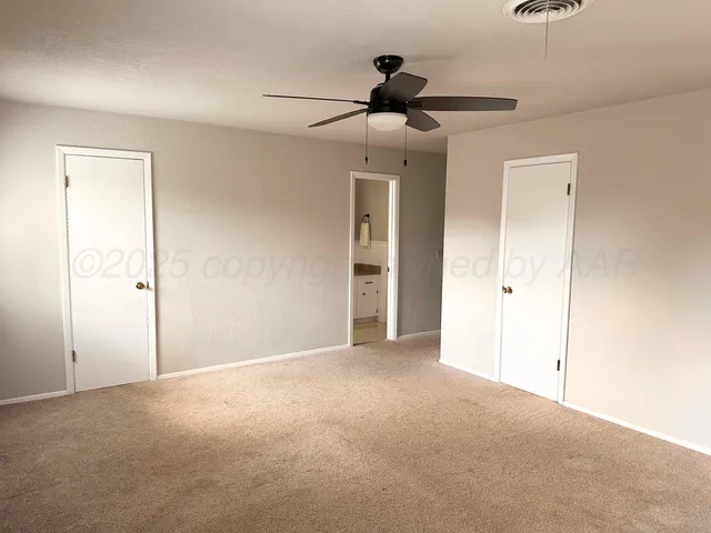 a view of empty room with ceiling fan