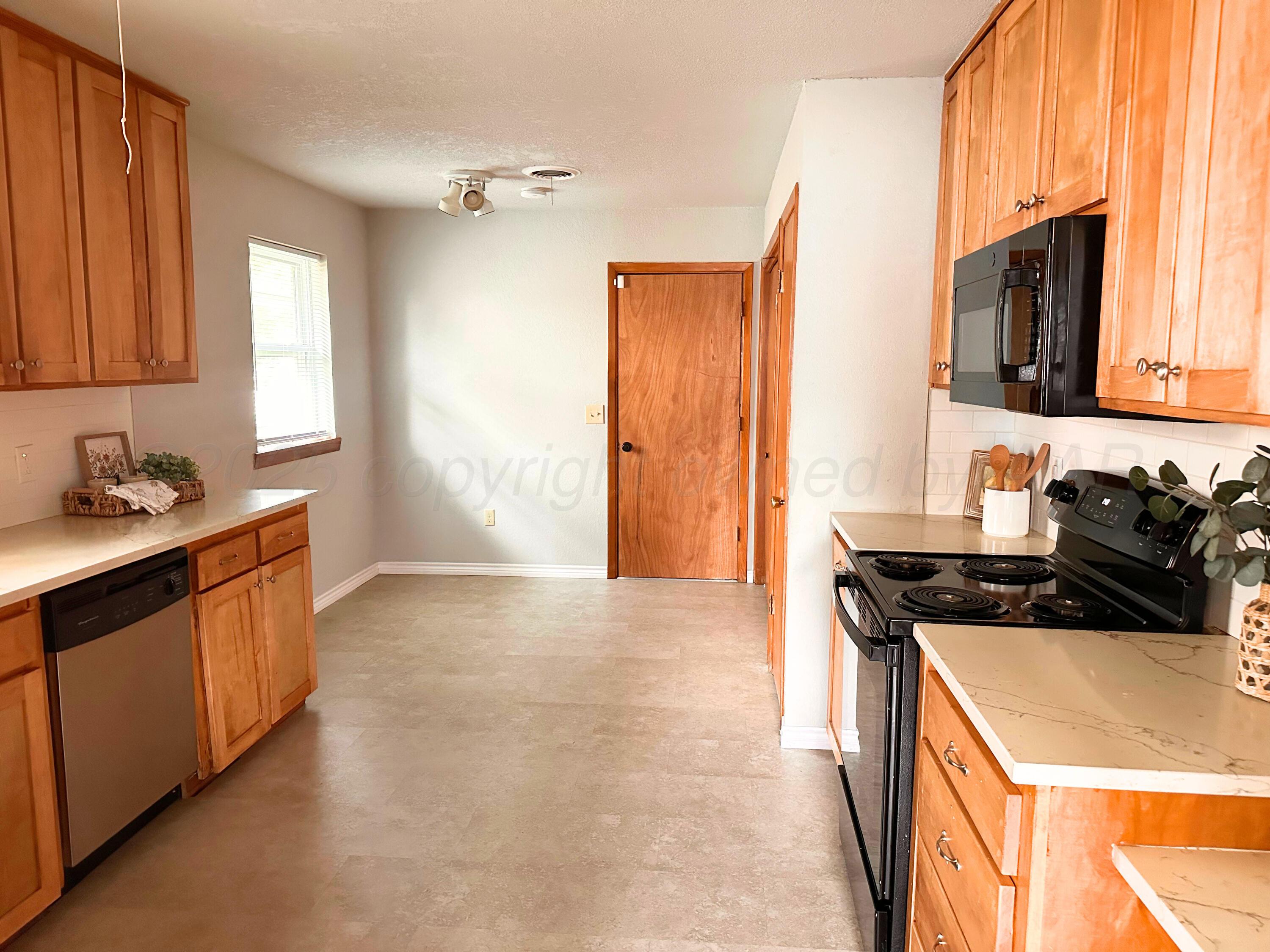 6007 Palmetto Trail Amarillo, TX 79106 - Photo 8 of 23 a kitchen with stainless steel appliances granite countertop a sink stove and refrigerator