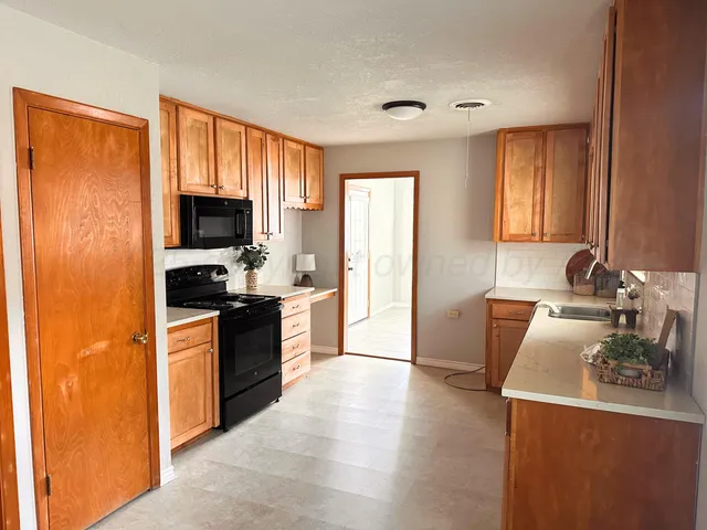 a large kitchen with a window a sink and a stove top oven