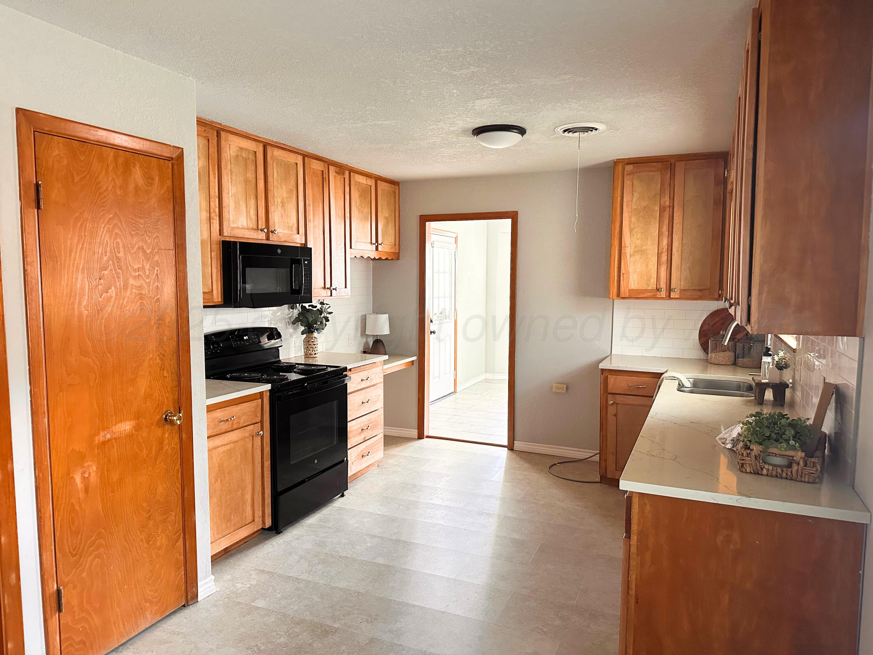 6007 Palmetto Trail Amarillo, TX 79106 - Photo 9 of 23 a large kitchen with a window a sink and a stove top oven