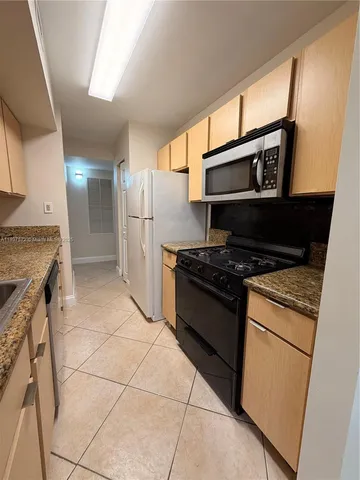 a kitchen with stainless steel appliances granite countertop a stove and a refrigerator