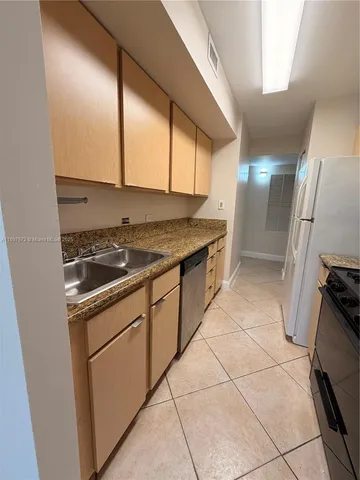 a kitchen with a stove a sink and a refrigerator