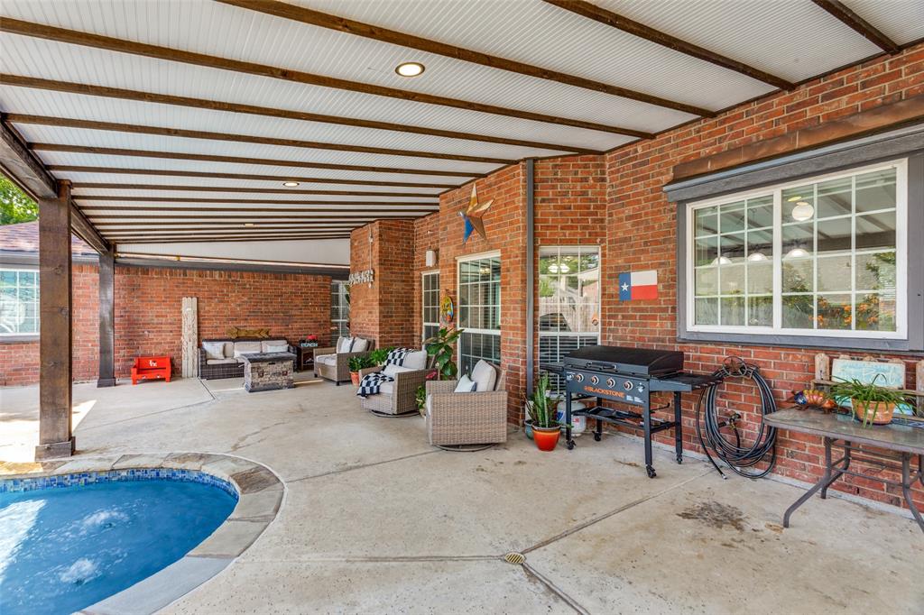 1228 Concho Drive Benbrook, TX 76126 - Photo 36 of 39 Covered patio area featuring a concrete deck and a partially visible pool with stone coping