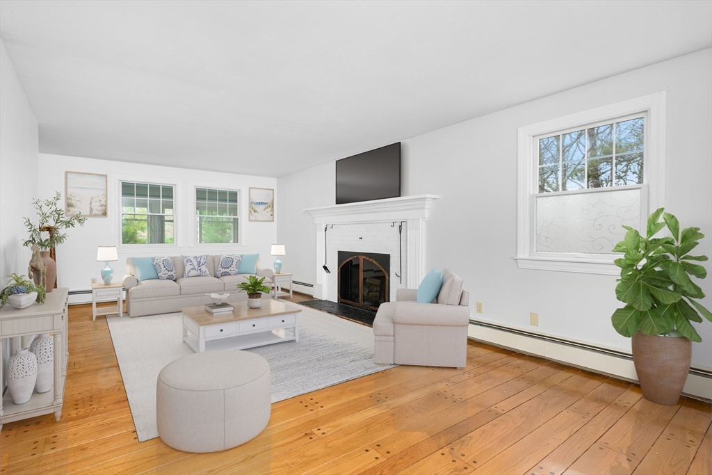 25 Robert Road Harwich, MA 02645 - Photo 5 of 36 a living room with furniture potted plant and a fireplace