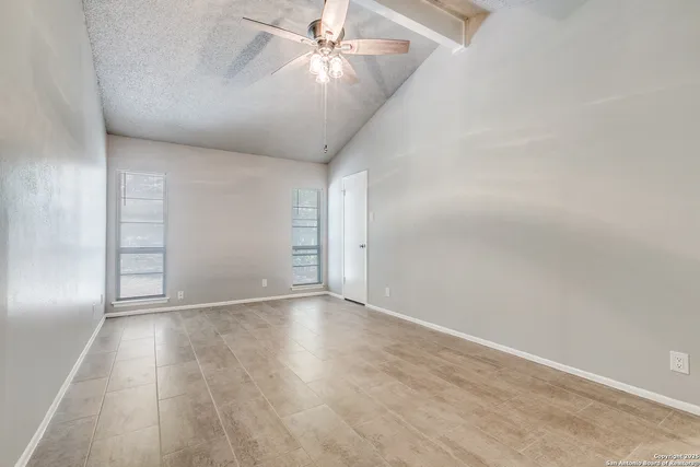 a view of an empty room with wooden floor