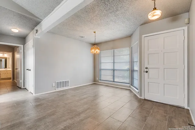 an empty room with closet and windows