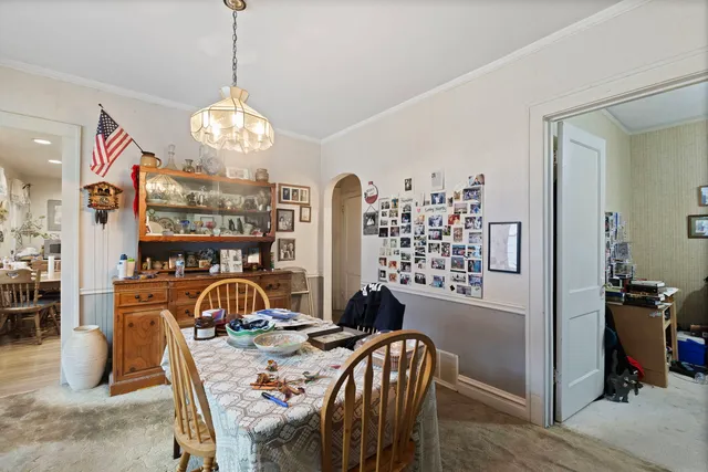 a view of a dining room with furniture a chandelier and wooden floor