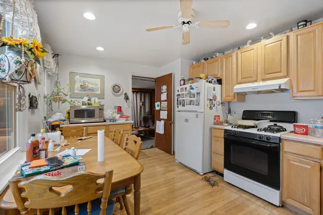 a kitchen with stainless steel appliances granite countertop a stove refrigerator and a view of living room