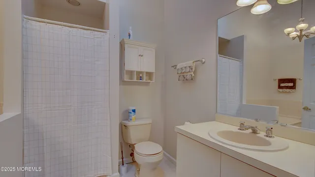 a bathroom with a sink a toilet and shower curtain