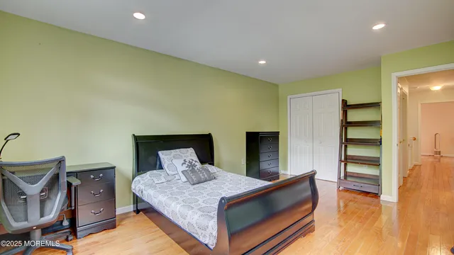 a spacious bedroom with a bed and wooden floor