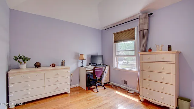 a view of a workspace with furniture and a window