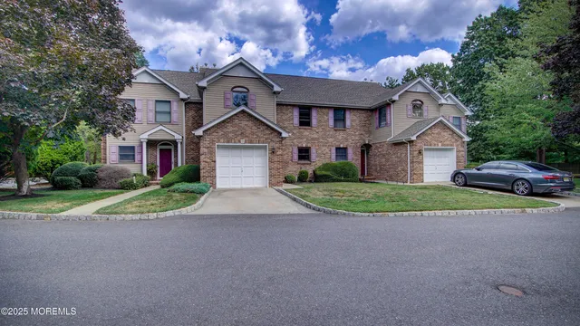 a view of a big house with a big yard and large trees