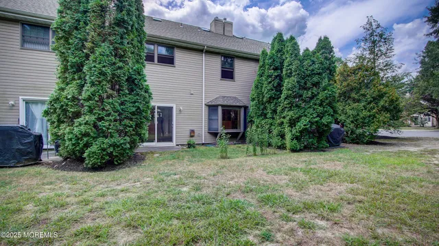 a view of a house with a yard and potted plants
