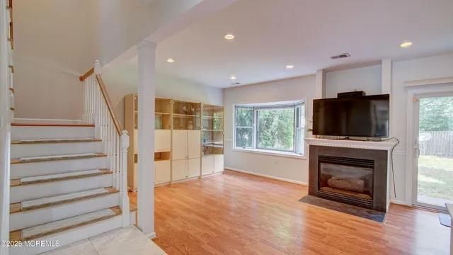 a view of a livingroom with a fireplace wooden floor and windows