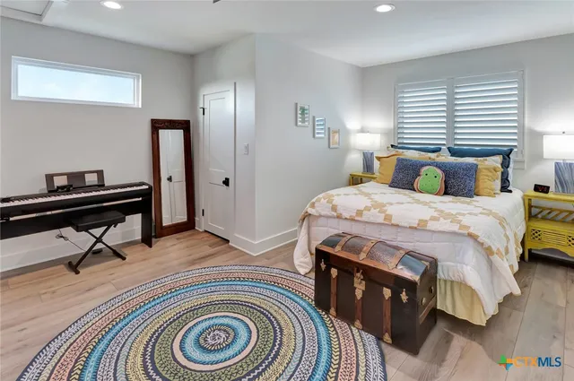 a bedroom with a bed and a dresser next to a window