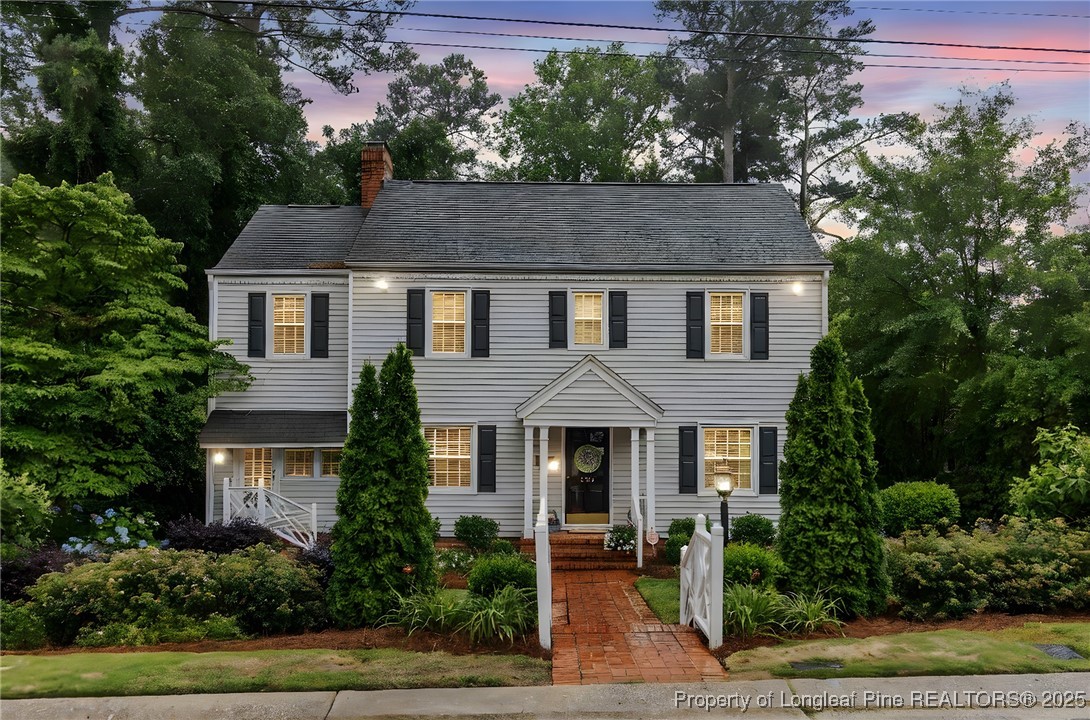 a front view of a house with plants and trees