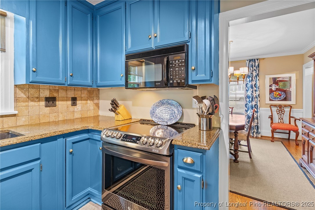503 Rush Road Fayetteville, NC 28305 - Photo 15 of 50 a kitchen with stainless steel appliances granite countertop a stove and a wooden cabinets