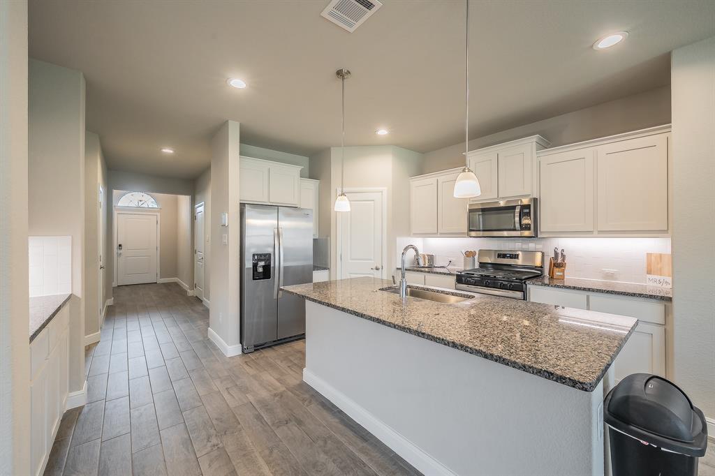 1212 Bosque Lane Weatherford, TX 76087 - Photo 6 of 38 a kitchen with refrigerator and cabinets