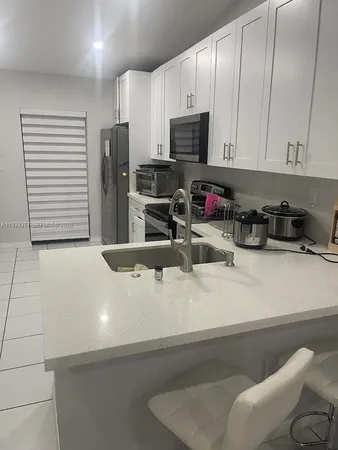 a kitchen with stainless steel appliances granite countertop a sink a stove and a refrigerator