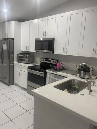 a kitchen with granite countertop a sink and white stainless steel appliances