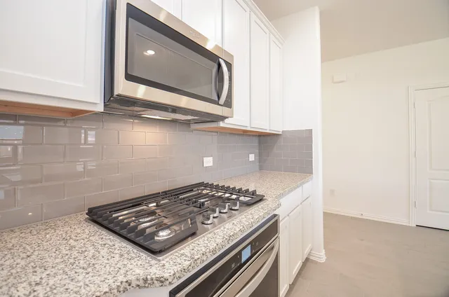 a stove top oven sitting inside of a kitchen