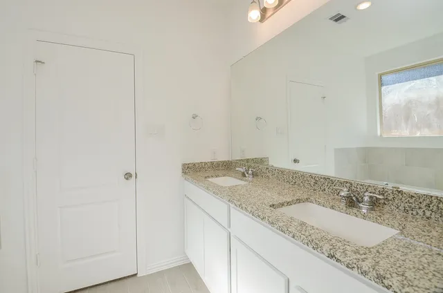 a bathroom with a granite countertop sink and a mirror