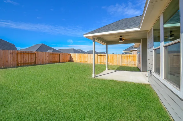 a view of an house with backyard and patio